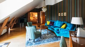 Suite med siddegruppe, lænestole, sofa og lysekrone hos Clarion Hotel Örebro