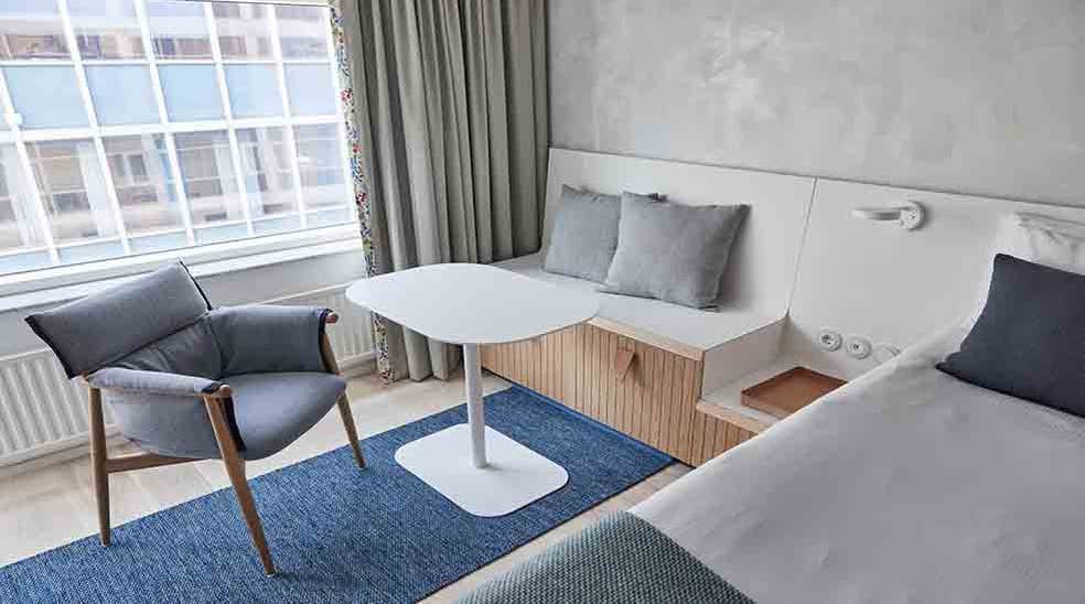 Siddeplads med bord samt stol i skandinavisk design i Superior Double hotellrum med fönster på Nordic Light Hotel i Stockholm