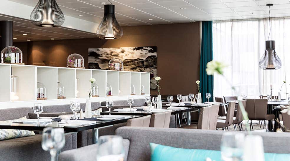 Spiseområde med sofa, stole og dækket bord med vinglas i restauranten hos Quality Airport Hotel Værnes