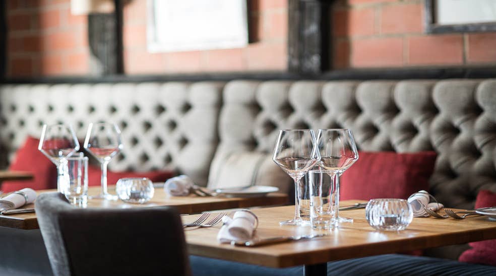 Sofa, glas og bestik på dækket bord i Cooks Restaurant hos Quality Hotel Luleå