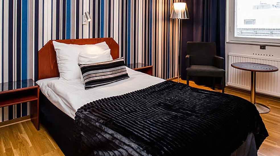 Moderate værelse med seng og stribet tapet hos Quality Hotel Statt i Hudiksvall